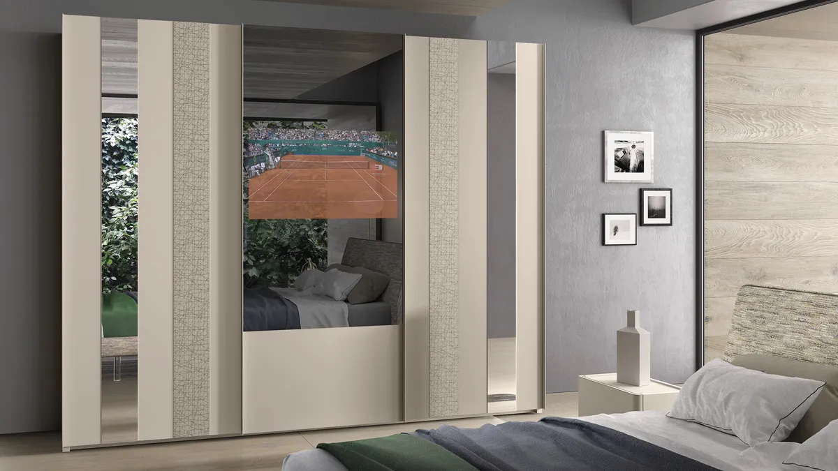 Armadio 12 con ante scorrevoli in laccato opaco, materico decor e specchio con TV di Corso 11